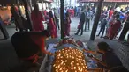 Seorang umat Hindu melakukan ritual dengan berbaring di tempat tidur yang ditutupi dengan 108 lampu minyak menyala pada hari kesepuluh festival Dashain di sebuah kuil di Bhaktapur di pinggiran Kathmandu (15/10/2021). (AFP/Prakash Matematika)