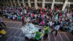 Panitia membagikan nasi kotak jelang buka puasa bersama di Masjid Istiqlal, Jakarta, Senin (6/5/2019). Umat muslim yang ingin mengikuti buka puasa bersama sudah berdatangan sejak sore hari. (Liputan6.com/Faizal Fanani)