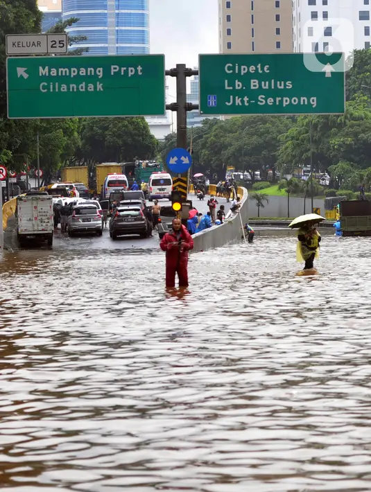Suasana banjir yang menggenangi Jalan Tol JORR di kawasan TB Simatupang, Jakarta Selatan, Sabtu (20/2/2021). Banjir terjadi akibat luapan Kali Serua yang berada di pinggir jalan tol. (merdeka.com/Arie Basuki)