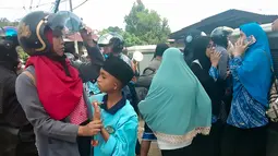 Warga berkumpul di jalanan setelah gempa berkekuatan magnitudo 6,8 di desa Batu Merah di Ambon, kepulauan (26/9/2019). Gempa ini dirasakan dengan skala MMI V di Ambon, skala MMI V di Kairatu, MMI II-III di Paso, dan II di Banda. (AFP Photo/Yusnita)