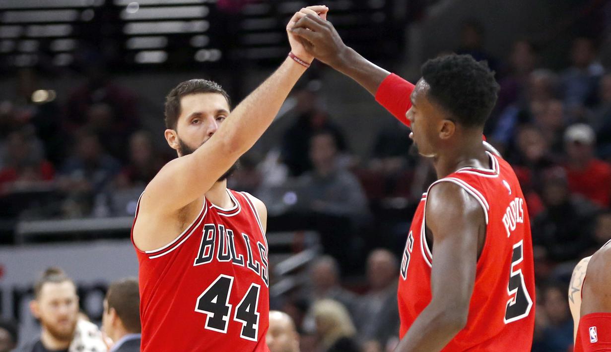 Pemain Chicago Bulls, Nikola Mirotic (44) dan Bobby Portis merayakan keberhasilan timnya meraih poin saat melawan Boston Celtics pada lanjutan NBA basketball game di United Center, Chicago, (11/12/2017). Bulls menang 108-85. (AP/Charles Rex Arbogast)