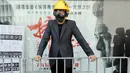 Seorang pengacara mengenakan helm dan masker saat berdemonstrasi di Hong Kong, Rabu (7/8/2019). Ratusan pengacara mendukung tuntutan gerakan prodemokrasi untuk penyelidikan independen terhadap penegakan hukum terkait demonstrasi menolak RUU Ekstradisi. (AP Photo/Kin Cheung)