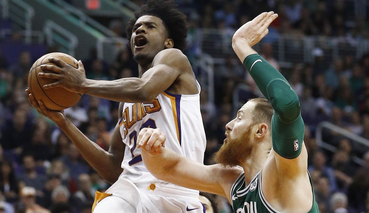 Pebasket Boston Celtics, Aron Baynes, menghadang pebasket Phoenix Suns, Josh Jackson, pada laga NBA di Talking Stick Resort Arena, Selasa (27/3/2018). Boston Celtics menang 102-94 atas Phoenix Suns. (AP/Ross D. Franklin)