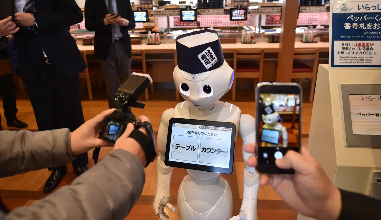 Fotografer mengambil gambar robot humanoid Pepper saat press preview di Saitama, Jepang (2/2). Pepper yang diproduksi oleh Softbank dirancang khusus dengan perangkat lunak dari perusahaan Belgia Zora Botts. (AFP/Kazuhiro Nogi)