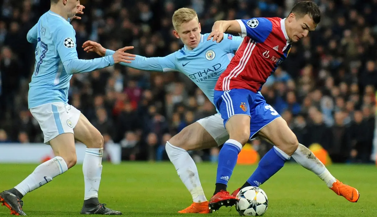 Dua pemain Manchester City berusaha merebut bola dari gelandang FC Basel Kevin Bua saat pertandingan Liga Champions leg kedua  di Stadion Etihad, Manchester (7/3). Manchester City menang agregat 5-2 atas FC Basel. (AP Photo / Rui Vieira)