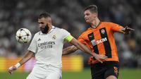 Penyerang Real Madrid Karim Benzema berebut bola dengan bek Shakhtar Donetsk Valeriy Bondar dalam matchday ketiga Grup F Liga Champions 2022/2023 di Santiago Bernabeu, Kamis dini hari WIB (6/10/2022).Tak ada gol tambahan sepanjang babak kedua. Real Madrid keluar sebagai pemenang. (AP Photo/Bernat Armangue)