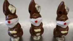 Cokelat paskah berbentuk kelinci yang mengenakan masker di toko roti Baeckerei Bohnenblust di Bern, Swiss, Jumat (27/3/2020). Cokelat berbentuk kelinci dengan masker berwarna putih dari tepung gula ini dibuat di tengah pandemi virus corona yang sedang merebak di seluruh dunia. (STEFAN WERMUTH/AFP)