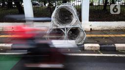 Gulungan kawat berduri diletakkan di atas trotoar Jalan Asia Afrika, Jakarta Pusat, Selasa (28/12/2021). Kawat berduri yang berada di trotoar tersebut sangat mengganggu para pejalan kaki yang melintas. (Liputan6.com/Johan Tallo)