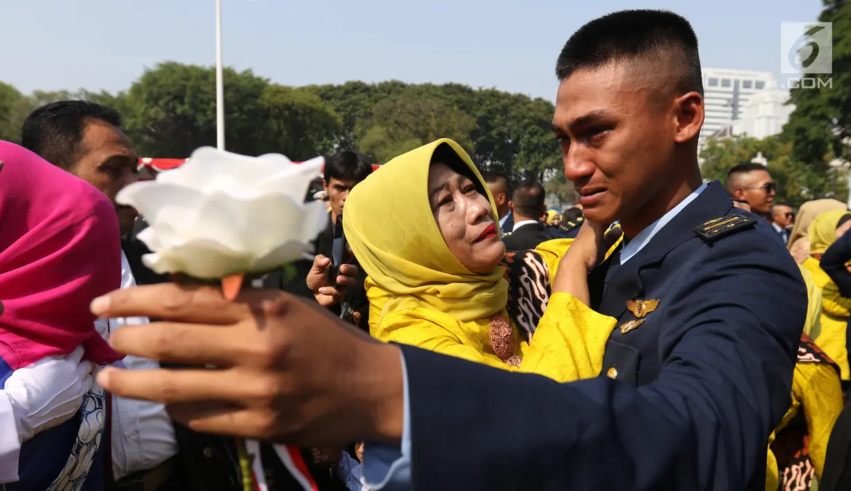 Perwira TNI-Polri menangis bersama orangtuanya usai dilantik Presiden Joko Widodo atau Jokowi di halaman Istana Merdeka, Jakarta Pusat, Selasa (16/7/2019). Jokowi melantik 781 perwira TNI-Polri di Istana Merdeka. (Liputan6.com/Angga Yuniar)