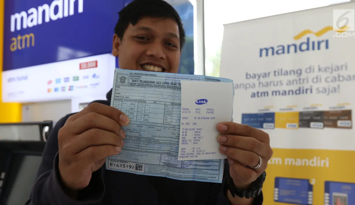 Warga menunjukkan bukti pembayaran tilang online melalui atm Bank Mandiri di Jakarta, Kamis (3/1). Bank Mandiri berkerjasama dengan Kejari Jakpus dalam penerimaan pembayaran tilang non tunai atau secara online. (Liputan6.com/Angga Yuniar)