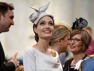Aktris Angelina Jolie menghadiri acara Service of Commemoration and Dedication St Michael & St George di Katedral St. Paul, London, Kamis (28/6). Angelina Jolie terlihat memukau dalam balutan midi dress abu-abu yang super anggun. (Leon Neal/PA via AP)