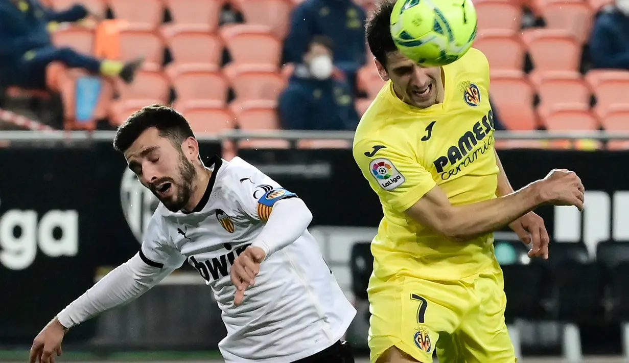 Bek Valencia, Jose Gaya (kiri) berebut bola dengan penyerang Villarreal, Gerard Moreno pada pertandingan lanjutan La Liga Spanyol di stadion Mestalla di Valencia (6/3/2021). Valencia sempat tertinggal lebih dulu lewat gol penalti Gerard Moreno pada menit ke-40. (AFP/Jose Jordan)