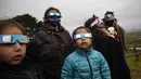 Keluarga Adat Mapuche menggunakan kacamata khusus untuk mencoba mengamati gerhana matahari total di Carahue, La Araucania, Chile, Senin (14/12/2020). Gerhana matahari total terlihat dari Chile dan wilayah Patagonia utara Argentina. (AP Photo/Esteban Felix)