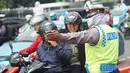 Polisi memberi arahan pada pengendara motor di sekitar lokasi pengalihan arus lalu lintas di Jalan Medan Merdeka Timur, Jakarta, Jumat (14/6/2019). Pengalihan arus dilakukan di sejumlah titik menuju Gedung Mahkamah Konstitusi terkait sidang sengketa Pilpres 2019. (Liputan6.com/Immanuel Antonius)