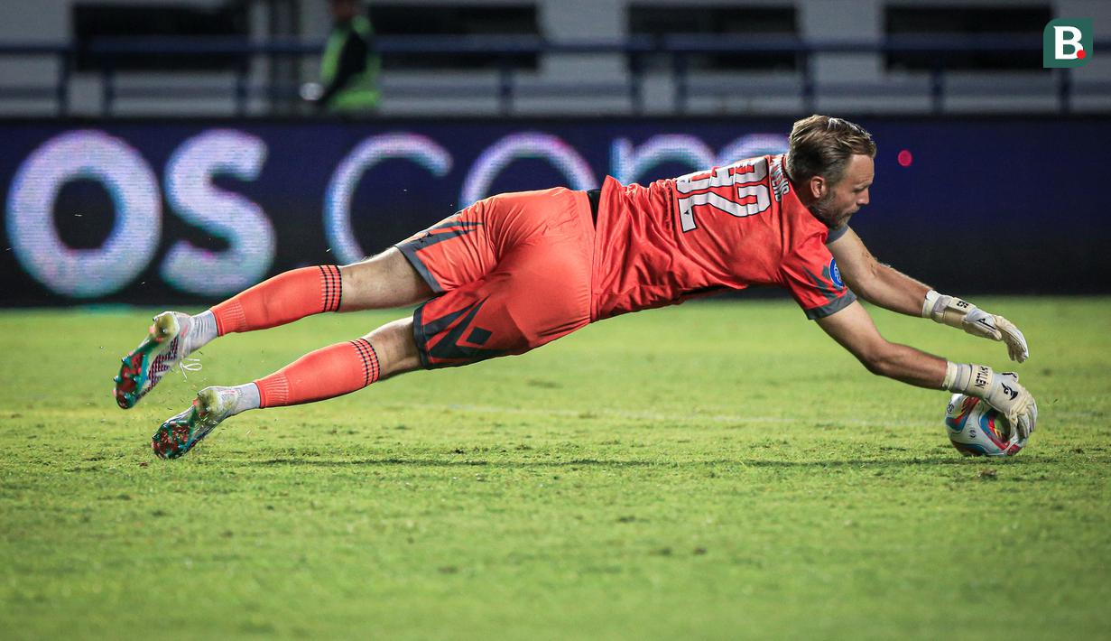 Kiper Dewa United, Sonny Stevens berusaha menangkap bola pada laga pekan ketiga BRI Liga 1 2023/2024 antara Persib Bandung melawan Dewa United di Stadion GBLA, Bandung, Jumat (14/07/2023). (Bola.com/Bagaskara Lazuardi)