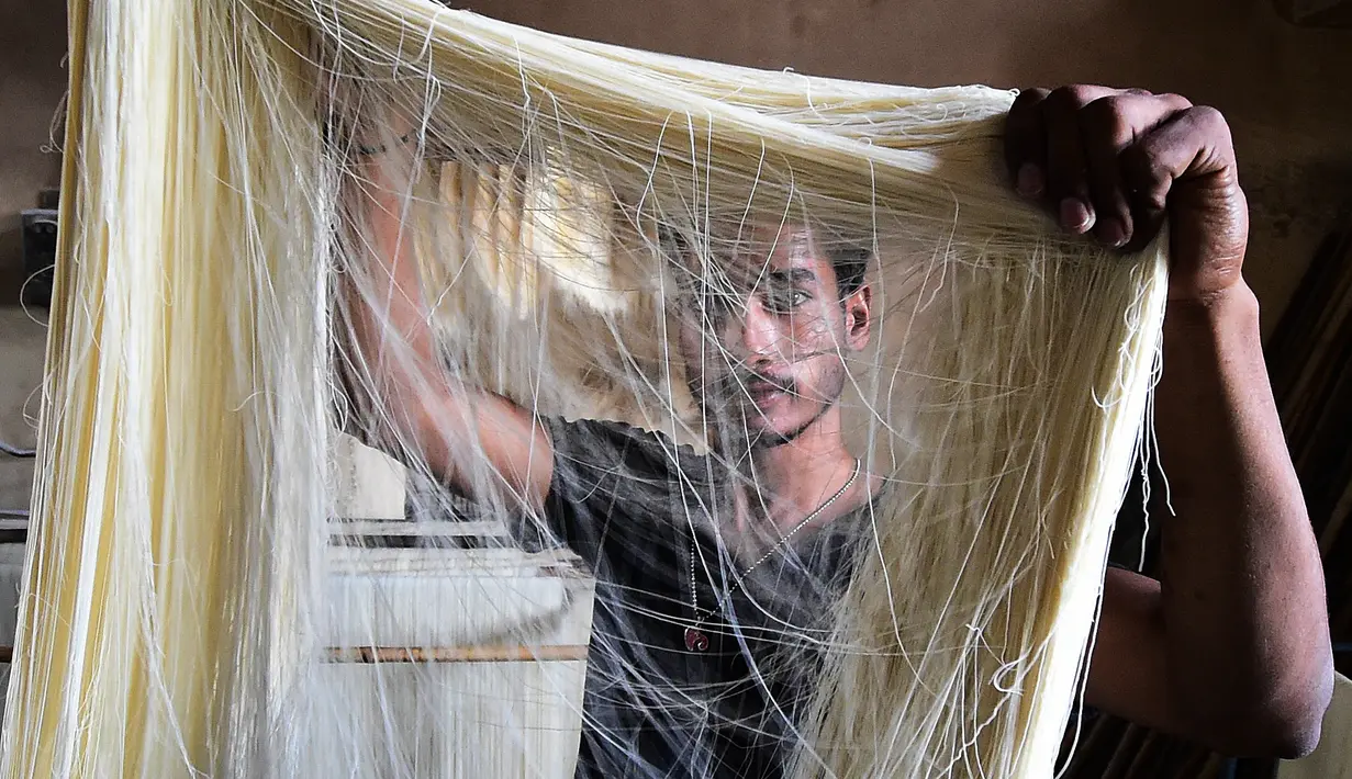 Pekerja menyiapkan bihun yang digunakan dalam hidangan manis tradisional yang populer dikonsumsi selama bulan suci Ramadhan di sebuah pabrik di Allahabad, India (13/4/2021). (AFP Photo/Sanjay Kanojia)