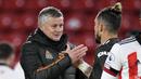 Manajer Manchester United, Ole Gunnar Solskjaer (kiri), memberi selamat pemainnya, bek Alex Telles, usai laga lanjutan Liga Inggris 2020/21 pekan ke-13 melawan Sheffield United di Bramall Lane, Sheffield, Kamis (17/12/2020). Manchester United menang 3-2 atas Sheffield United. (AFP/Peter Powell/Pool)