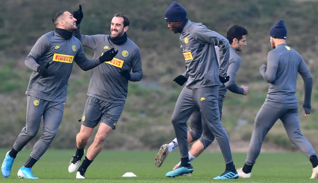 Pemain Inter Milan Diego Godin (kedua kiri) bercanda dengan Danilo D'Ambrosio (kiri) saat sesi latihan jelang menghadapi Barcelona pada laga terakhir fase grup Liga Champions di Appiano Gentile, Italia, Senin (9/12/2019). Inter Milan akan menjamu Barcelona di Giuseppe Meazza. (Miguel MEDINA/AFP)