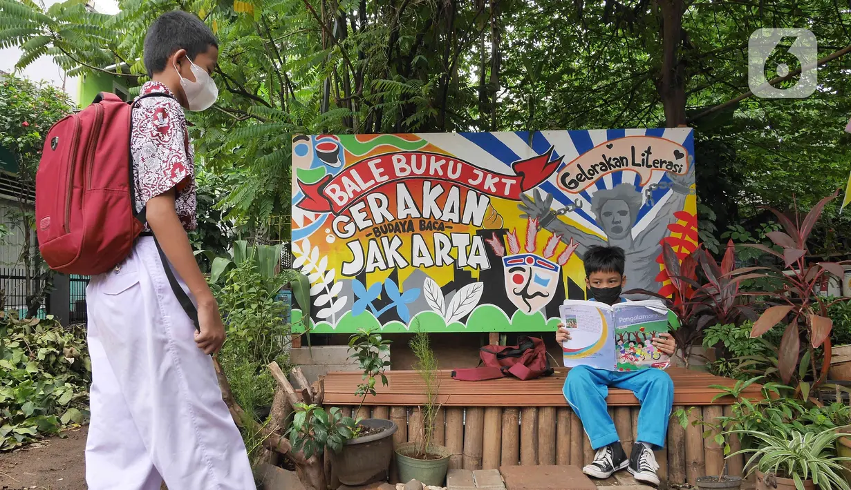 Seorang anak membaca buku di pustaka mini Bale Buku, Kramat Jati, Jakarta Timur, Kamis (20/01/2022). Bale buku yang diresmikan pada Sabtu (15/1) dibangun dari barang-barang bekas tersebut untuk memberi ruang bagi anak-anak serta warga agar gemar membaca. (Liputan6.com/Herman Zakharia)