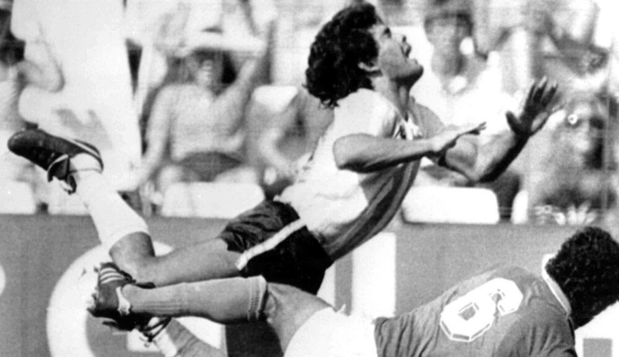 Penyerang Argentina, Diego Maradona, terjatuh saat berebut bola dengan pemain Italia, Claudio Gentile, pada laga Piala Dunia di Spanyol, (29/6/1982). (AP Photo, File)