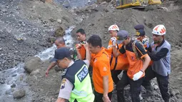 Petugas mengevakuasi korban tanah longsor di Magelang, Senin (18/12). Menurut pejabat setempat, delapan penambang tewas akibat longsor di lereng gunung berapi di pulau Jawa. (AFP Photo)