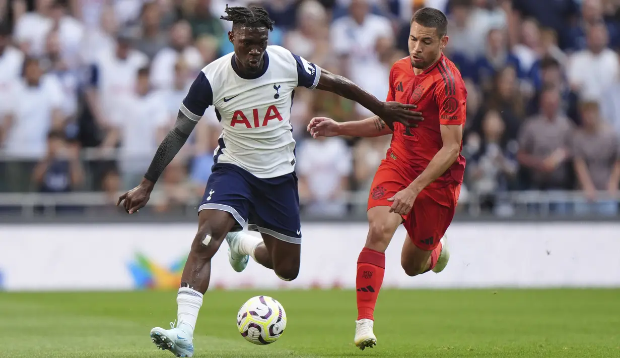Pemain Tottenham Hotspur, Yves Bissouma (kiri) menggiring bola dibayangi pemain Bayern Munchen pada laga persahabatan yang berlangsung di Tottenham Hotspur Stadium, London, Inggris, Minggu (11/08/2024) dini hari WIB. (AP Photo/PA/Bradley Collyer)