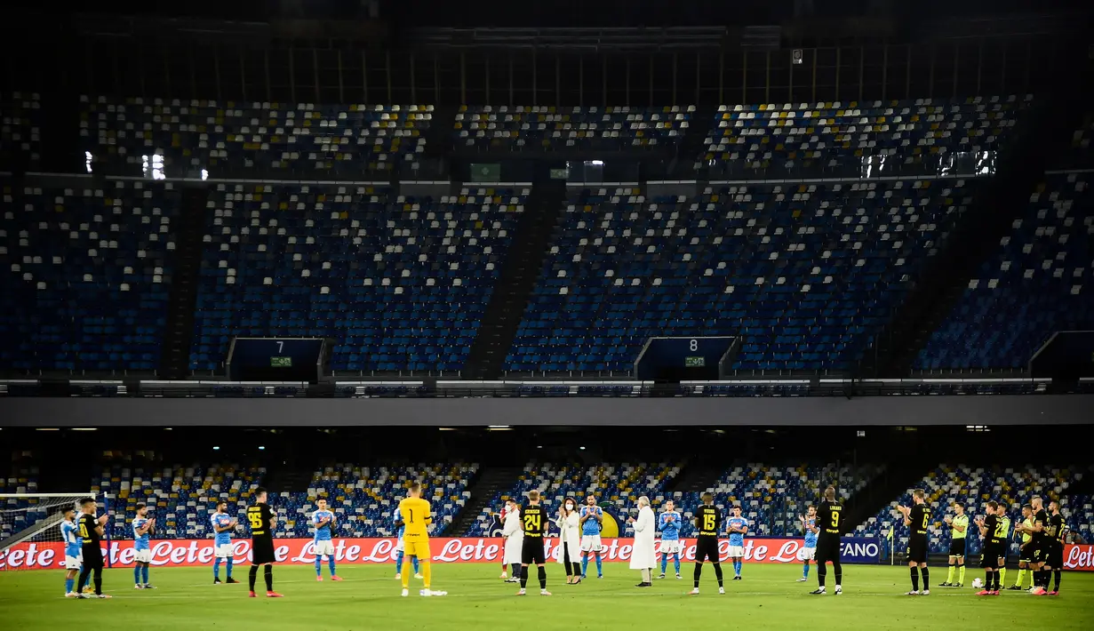 Para pemain Napoli dan Inter Milan bersama petugas medis mengheningkan cipta untuk para korban virus corona COVID-19 sebelum bertanding pada leg kedua semifinal Coppa Italia di San Paolo Stadium, Naples, Italia, Sabtu (13/6/2020). Pertandingan berakhir 1-1. (Filippo MONTEFORTE/AFP)