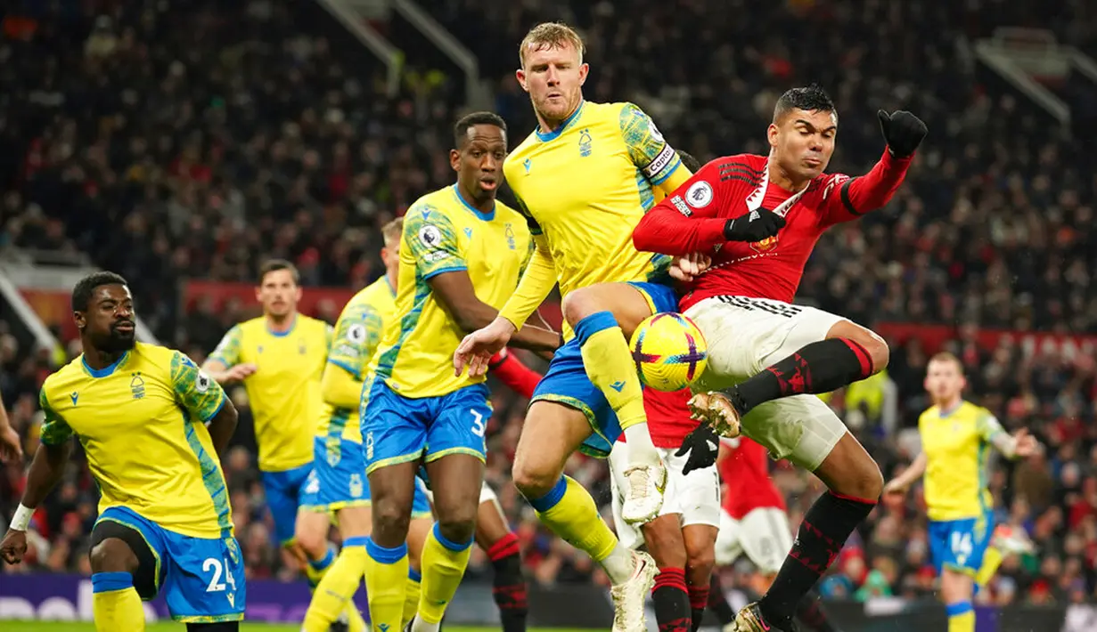 Pemain Manchester United Casemiro (kanan) berebut bola udara dengan pemain Nottingham Forest Joe Worrall pada pertandingan sepak bola Liga Inggris di Old Trafford, Manchester, Inggris, 27 Desember 2022. Manchester United mengalahkan Nottingham Forest dengan skor 3-0. (AP Photo/Dave Thompson)