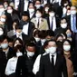 Para penumpang yang memakai masker wajah untuk melindungi dari penyebaran virus corona berjalan di sebuah jalan di Tokyo, 17 November 2020. (Foto: AP / Koji Sasahara)