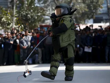  Seorang anggota tim penjinak bom membawa benda mencurigakan yang menghebohkan warga di kompleks kantor Singha Durbar, Kathmandu , Nepal, (1/3). Warga sekitar mendadak heboh karena mengira benda tersebut adalah sebuah bom. (REUTERS / Navesh Chitrakar)