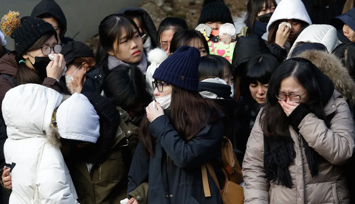 Tangis fans saat menghadiri prosesi pelepasan jenazah Jonghyun SHINee menuju tempat pemakaman dari Asan Hospital, Seoul, Kamis (21/12).Pihak keluarga dan SM Entertainment pun sepakat untuk merahasiakan lokasi pemakaman Jonghyun. (AP/Ahn Young-joon)