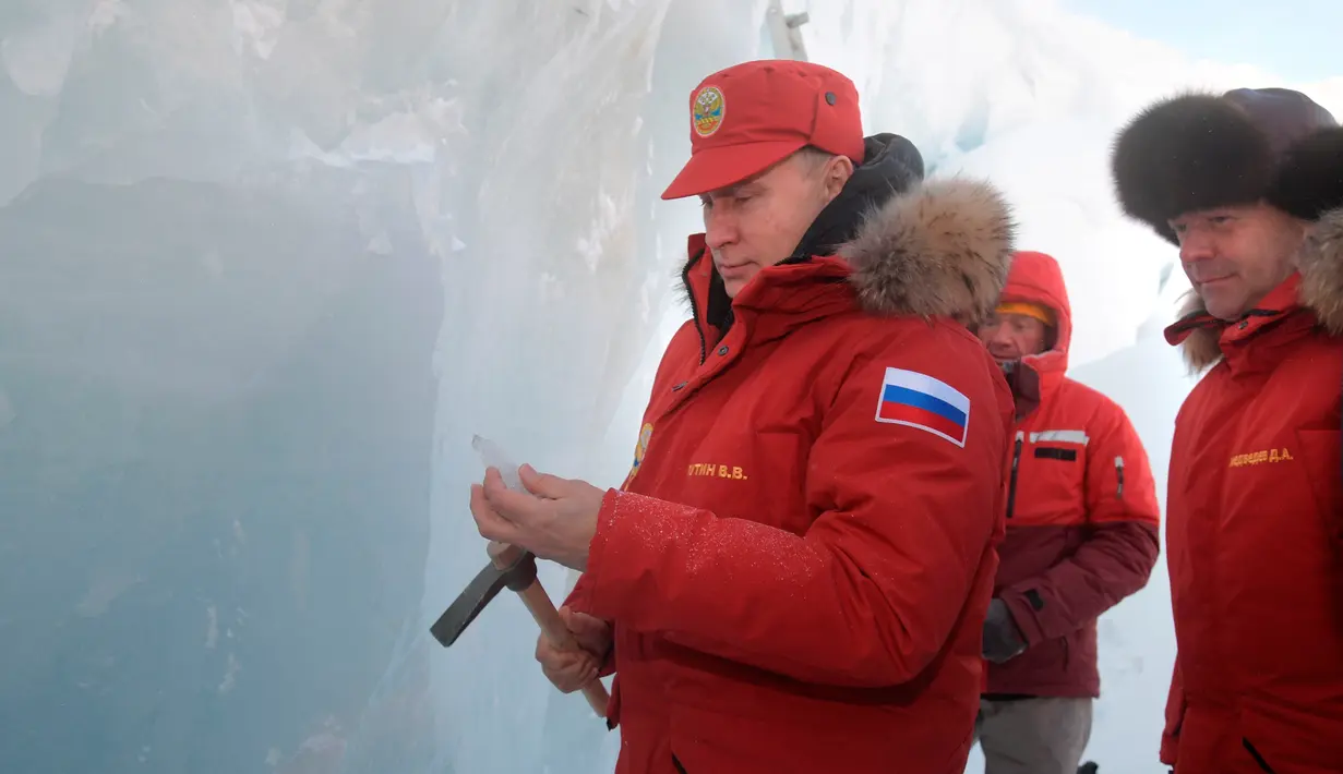 Presiden Rusia, Vladimir Putin bersama dengan PM Dmitry Medvedev saat menyusuri gletser kepulauan Arktik Franz Josef Land di Arctic Rusia, (29/3). (Alexei Druzhinin/Pool Photo via AP)