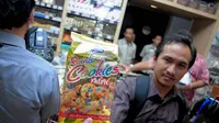 Seorang petugas menunjukan produk makanan yang disita BPOM dalam sidak di salah satu pusat perbelanjaan di Jakarta, Rabu (25/6/14). (Liputan6.com/Faizal Fanani)