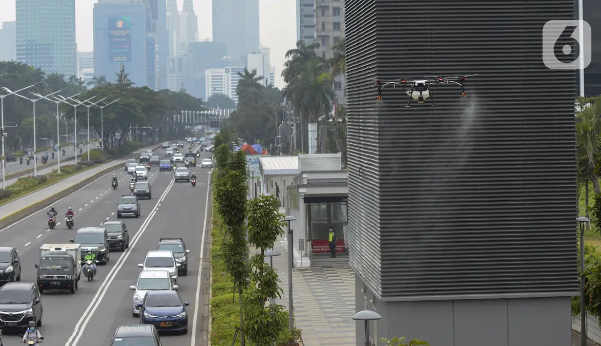 Drone menyemprotkan cairan disinfektan di Jalan Bursa Efek menuju Patung  Pemuda, Jakarta, Jumat (27/3/2020). Penyemprotan dilakukan untuk mencegah penyebaran virus corona COVID-19. (merdeka.com/Imam Buhori)