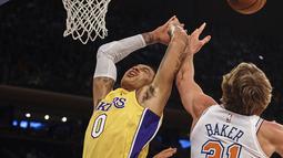 Pemain Los Angeles Lakers, Kyle Kuzma (tengah) gagal mencetak poin setelah diadang pemain New York Knicks, Ron Baker (31) pada lanjutan NBA basketball game di Madison Square Garden, New York, (12/12/2017). knicks menang 113-109. (AP/Andres Kudacki)