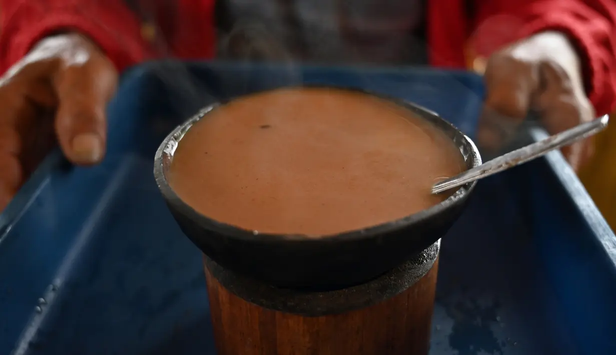 Seorang pria membawa kopi Kawa Daun di sebuah kafe tradisional di Tabek, Sumatera Barat (29/11).  Keunikan kopi di daerah ini adalah minuman yang mengekstrak rasa dari daun tanaman daripada kacangnya. (AFP Photo/Adek Berry)