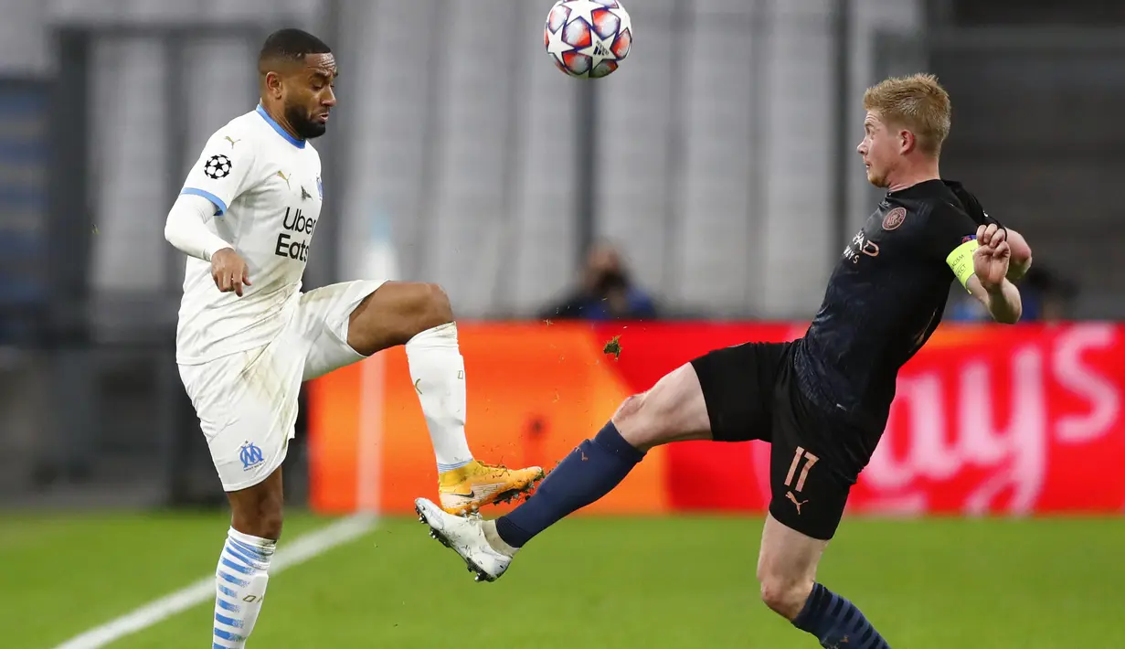 Gelandang Manchester City, Kevin De Bruyne berebut bola dengan pemain Marseille, Jordan Amavi pada pertandingan grup C Liga Champions di Stade Velodrome di Marseille, Prancis, Selasa (27/10/2020). City menang telak 3-0 atas Marseille. (Guillaume Horcajuelo/Pool via AP)