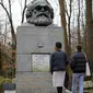 Pengunjung melihat makam filsuf ternama Jerman dan tokoh sosialisme, Karl Marx, di Pemakaman Highgate, London, Selasa (5/2). Tindakan vandalisme dengan menggunakan palu sudah dilaporkan ke kepolisian Scotland Yard. (Tolga AKMEN/AFP)