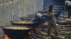 Seorang pria memasak kari tradisional untuk disajikan dalam makanan komunal selama bulan suci Ramadhan di Banda Aceh (25/4/2021). Menu ini sering dimasak setiap memperingati kenduri Nuzul Quran pada setiap pertengahan bulan suci Ramadhan. (AFP/Chaideer Mahyuddin)