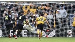 Dele Alli (kiri) menjadi keran gol Tottenham lewat tendangan pinalti setelah dirinya dijatuhkan di kotak dua belas pas. Ia sukses melesatkan bola ke sudut kiri dari arah kiper Wolves, Jose Sa. Papan skor berubah menjadi 1-0 dengan keunggulan The Lilywhites. (Foto: AP/Rui Vieira)