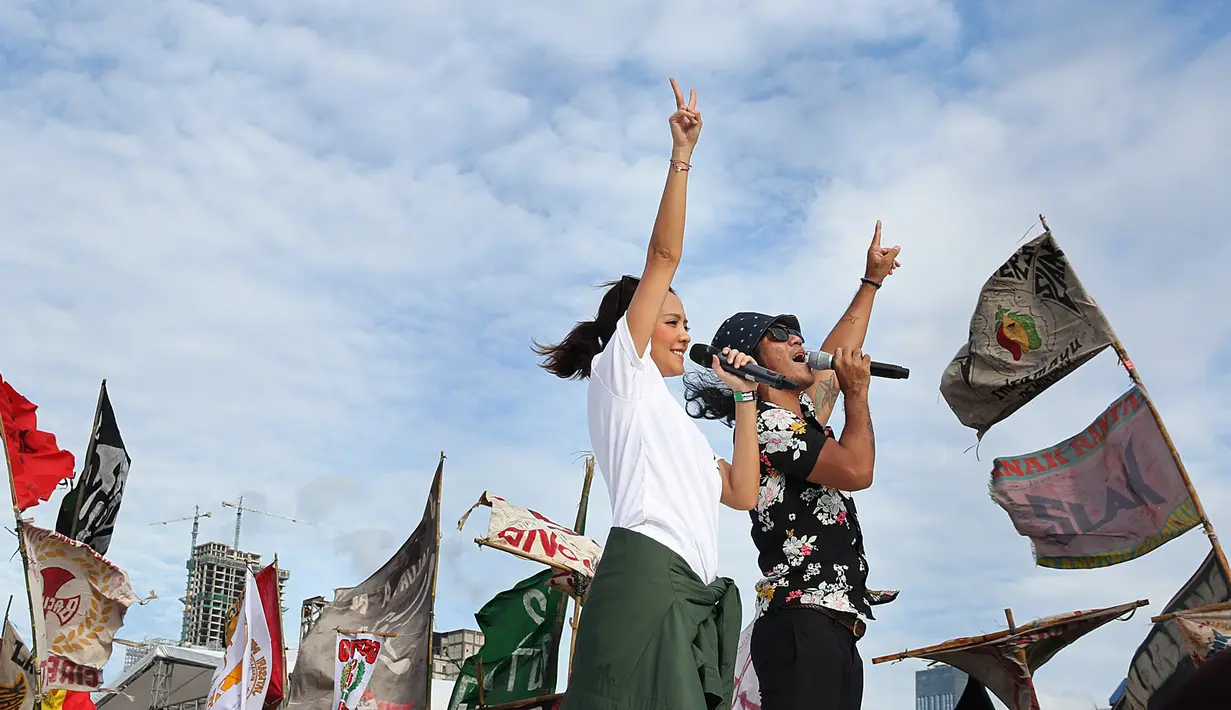 Bersama Lala Karmela, Slank membawakan lagunya yang bertajuk Seperti Para Koruptor. Tak peduli dengan panasnya terik matahari siang itu, penampilan keduanya tetap terlihat maksimal saat menghibur masyarakat di Konser Gue 2. (Bambang E. Ros/Bintang.com)