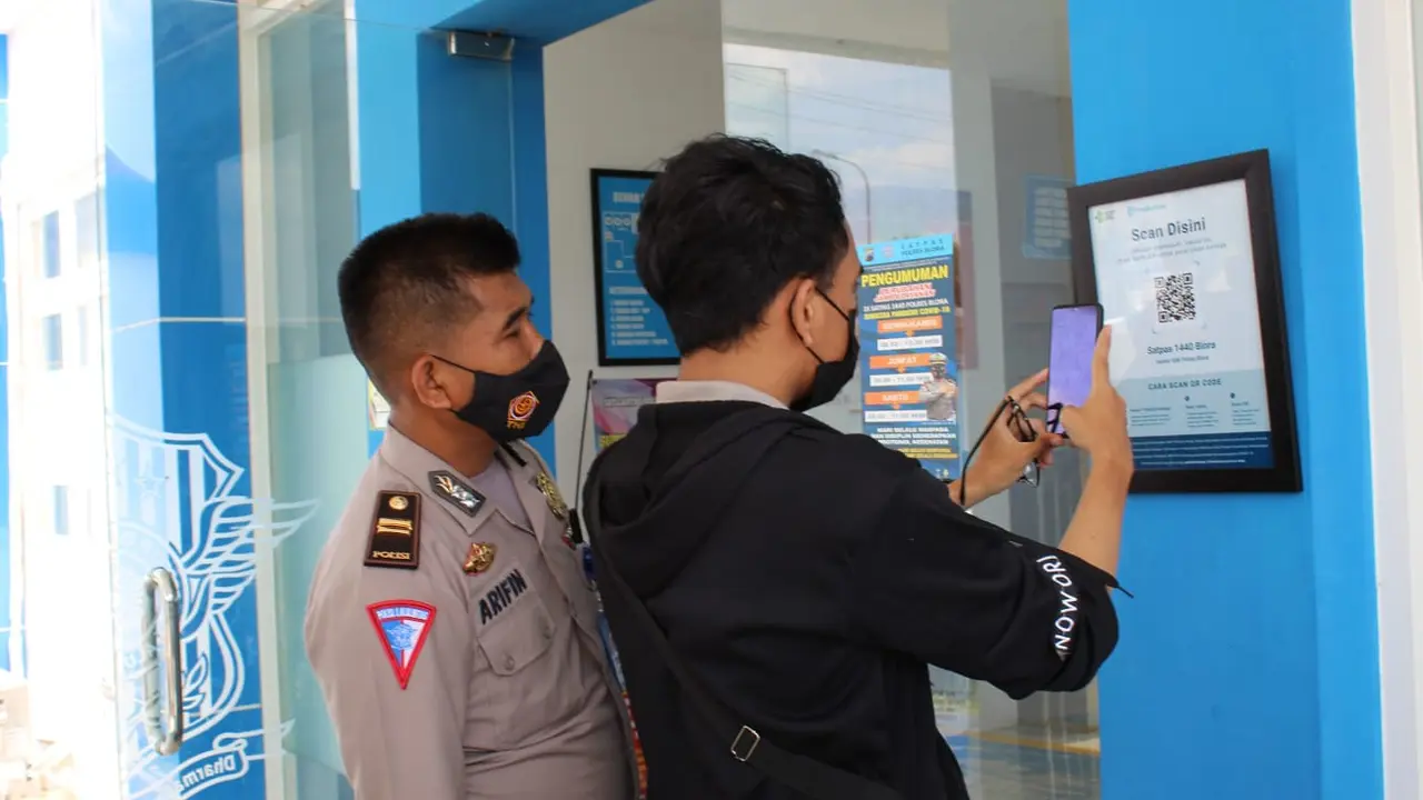 Pemohon SIM ketika menscan barcode aplikasi Peduli Lindungi di pintu keluar masuk Satpas Polres Blora. (Liputan6.com/Ahmad Adirin)