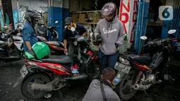 Sejumlah konsumen menunggu sepeda motornya diperbaiki usai terendam banjir di kawasan Mampang, Jakarta, Minggu (21/2/2021). Banjir yang melanda Ibu Kota Jakarta pada Sabtu (20/2) menyebabkan banyak kendaraan warga mengalami kerusakan akibat terendam air. (Liputan6.com/Faizal Fanani)
