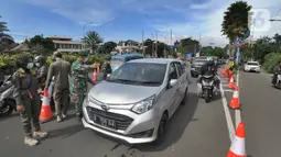 Petugas gabungan Satgas COVID-19 memeriksa kendaraan wisatawan di jalur wisata Puncak, Gadog, Bogor, Jawa Barat, Jumat (12/2/2021). Pemeriksaan dan penyekatan sebagai upaya meminimalisir penyebaran COVID-19 saat libur Tahun Baru Imlek 2572 dan akhir pekan. (merdeka.com/Arie Basuki)