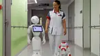 Seorang perawat berjalan bersama robot humanoid bernama Pepper (kiri) dan Zora di rumah sakit AZ Damiaan ,Ostend , Belgia, (16/6). Robot ini dirancang atau dibuat untuk mengurus pasien yang datang ke rumah sakit. (REUTERS / Francois Lenoir)