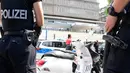 Dua polisi berjaga di depan rumah sakit pascapenembakan di sisi barat daya ibu kota Jerman, Berlin, Selasa (26/7). Pelaku penembakan yang merupakan pasien sakit itu bunuh diri setelah menembak mati seorang dokter. (Tobias Schwarz/AFP)