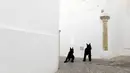Dua ekor anjing terlihat di antara bangunan serba putih di sebuah gang di Pueblos Blancos, Spanyol Selatan, 16 September 2016. Pueblos Blancos atau Desa Putih adalah salah satu daya tarik wisata yang unik di Andalusia. (REUTERS/Marcelo del Pozo)