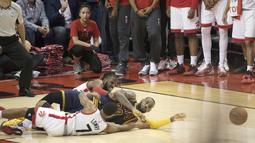 Pemain Cavaliers, LeBron James #23 berebut bola saat terjatuh dengan dua pemain Raptors pada game ke-4 Final Wilayah Barat  NBA Playoffs 2016 di Air Canada Centre, (23//5/2016). Raptors menang 105-99. (Nick Turchiaro-USA TODAY Sports)