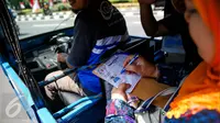 Seorang warga mengisi data saat menaiki bajaj bahan bakar gas (BBG) gratis dikawasan Monas Jakarta, Rabu (17/8). Selama satu minggu, PGN menyediakan total 700 bajaj gas atau 100 bajaj gas/hari. (Liputan6.com/Faizal Fanani)