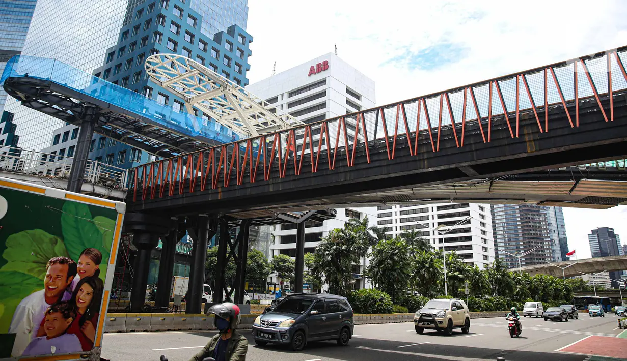 Sejumlah kendaraan melintas di bawah  revitalisasi JPO Sudirman di Jakarta, Senin (22/11/2021). Revitalisasi JPO Sudirman ditargetkan selesai pada akhir November 2021. (Liputan6.com/Faizal Fanani)